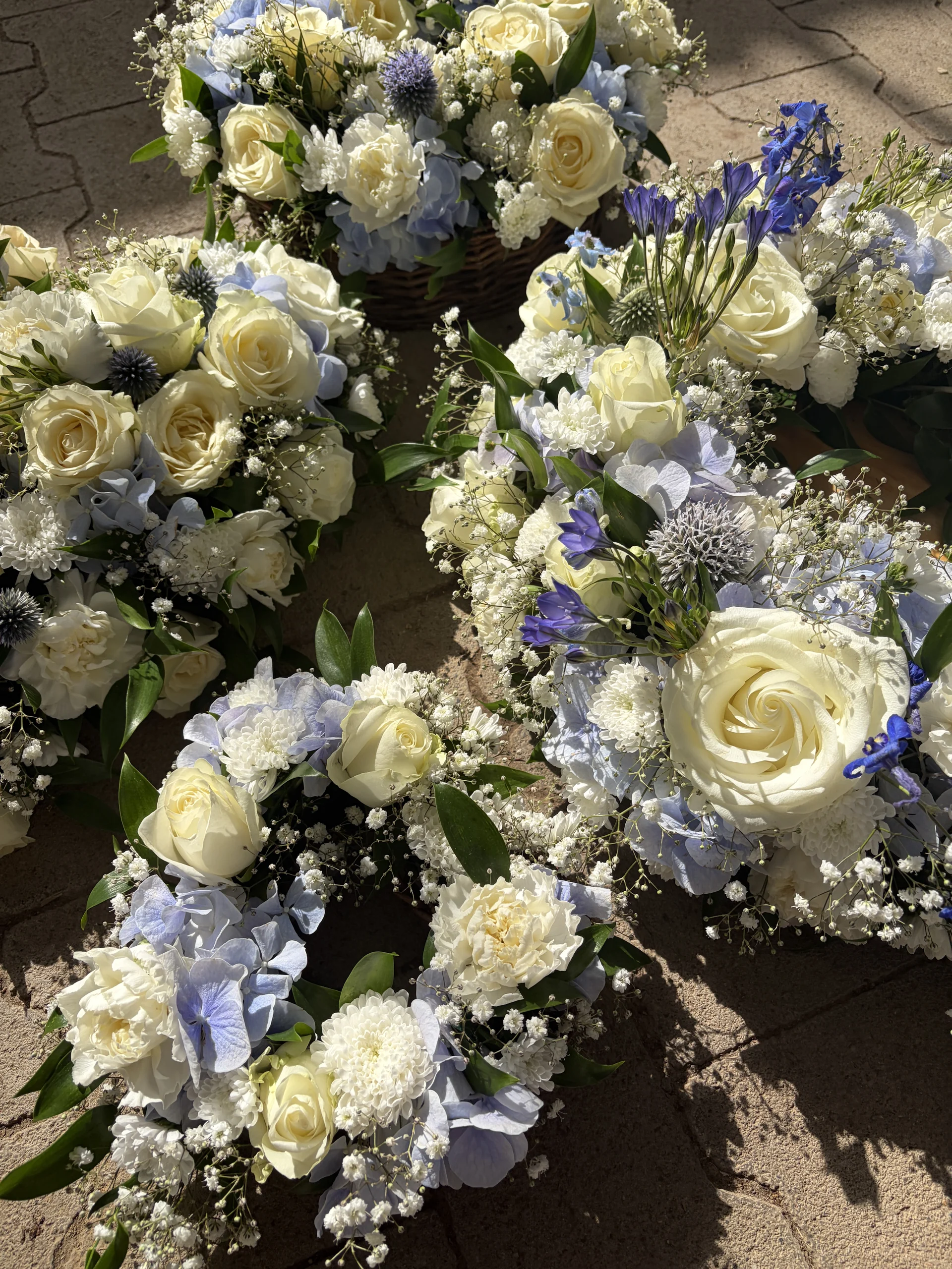 Mehrere floristische Arrangements in Weiß und Blau