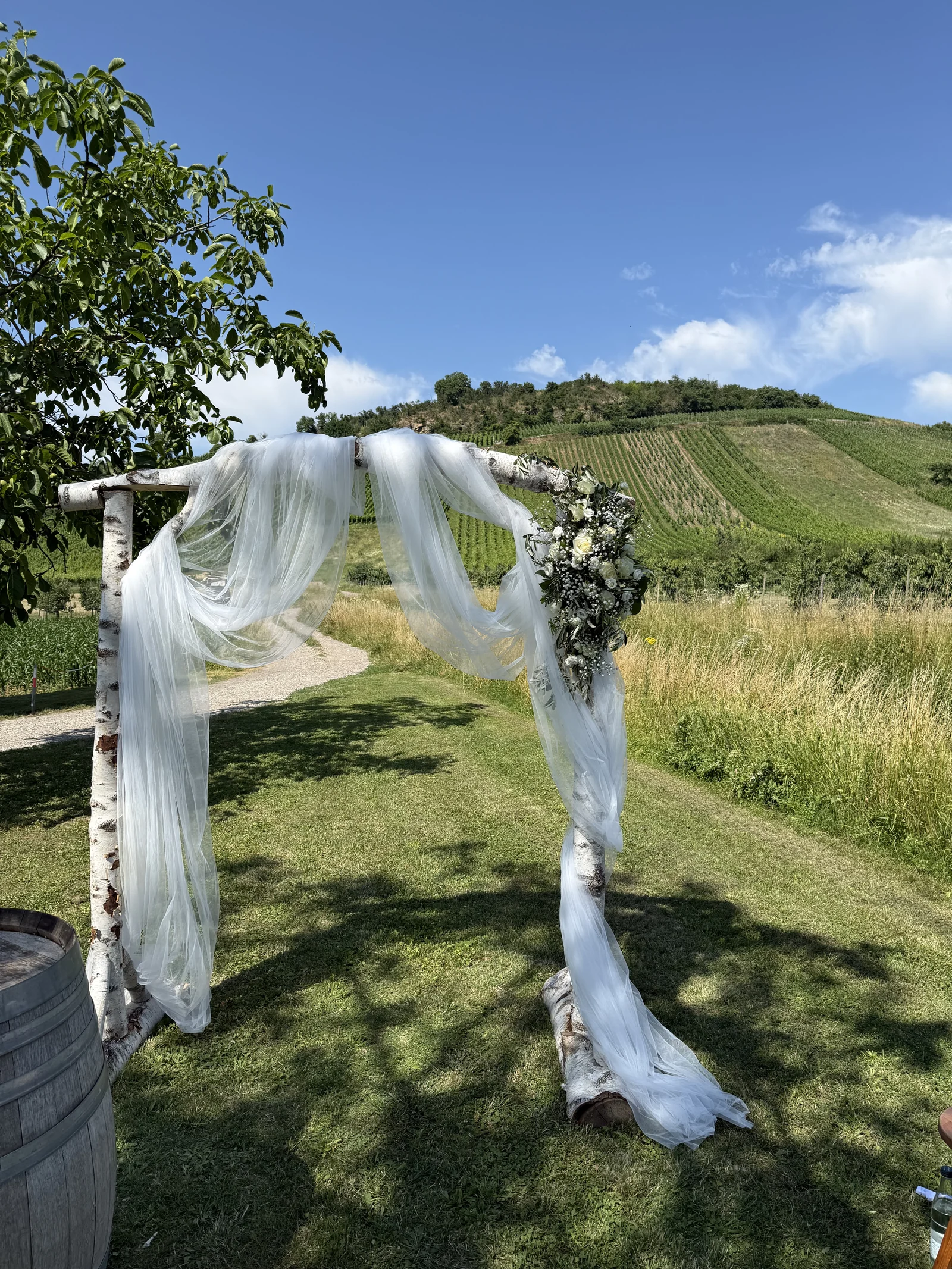 Blumenschmuck an einem Hochzeitsbogen im Weinberg