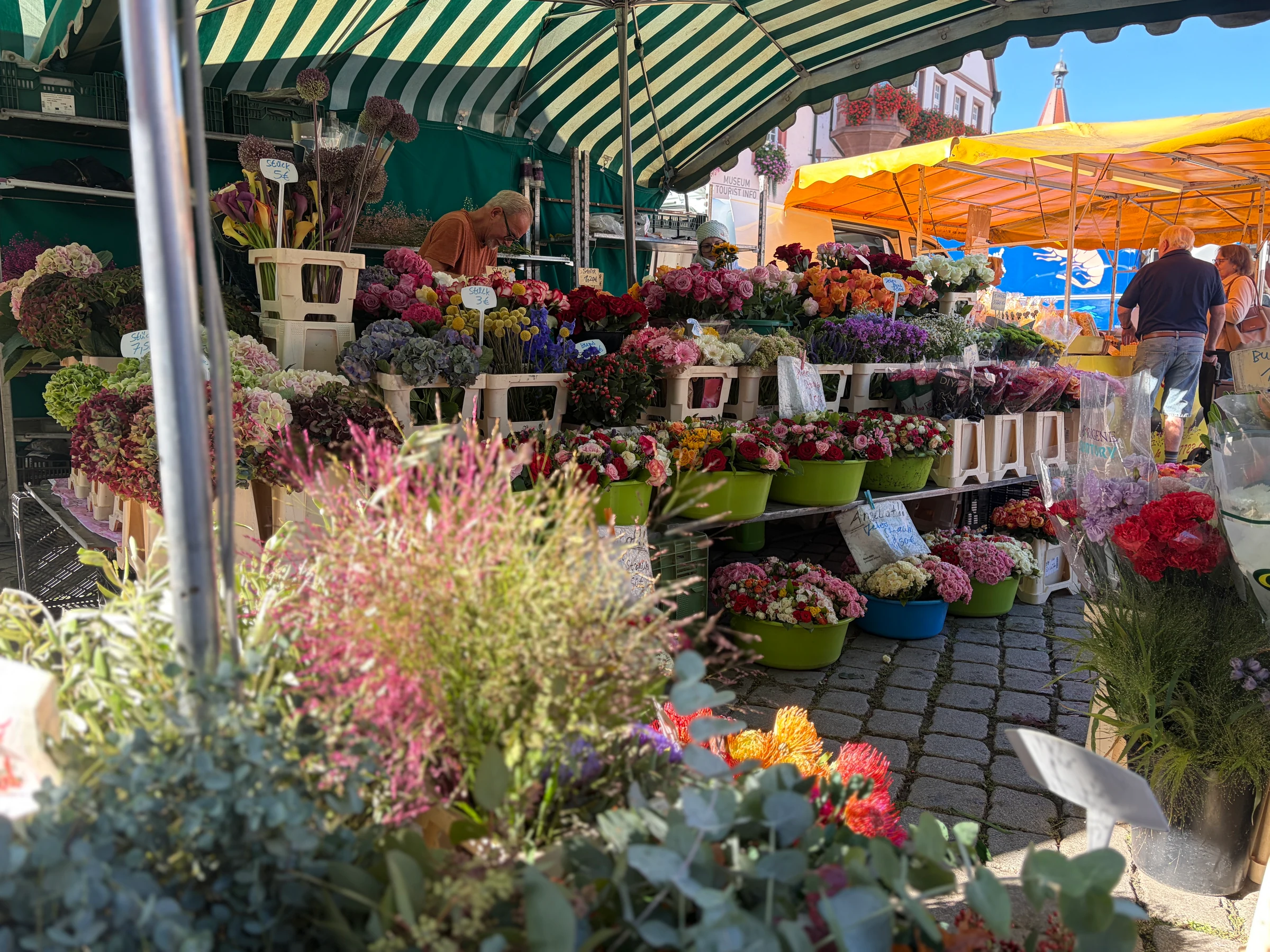 Rosen-Bähr-Blumenstand mit bunten Schnittblumen unter der gestreiften Markise in Gengenbach
