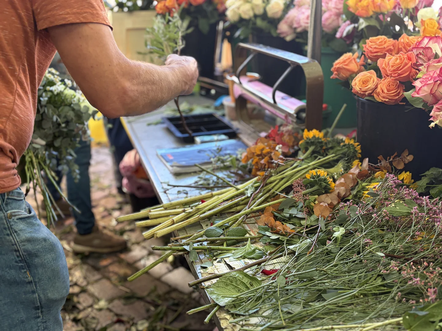 Floristische Handarbeit bei Rosen Bähr: Blumen und Stiele werden am Arbeitstisch vorbereitet